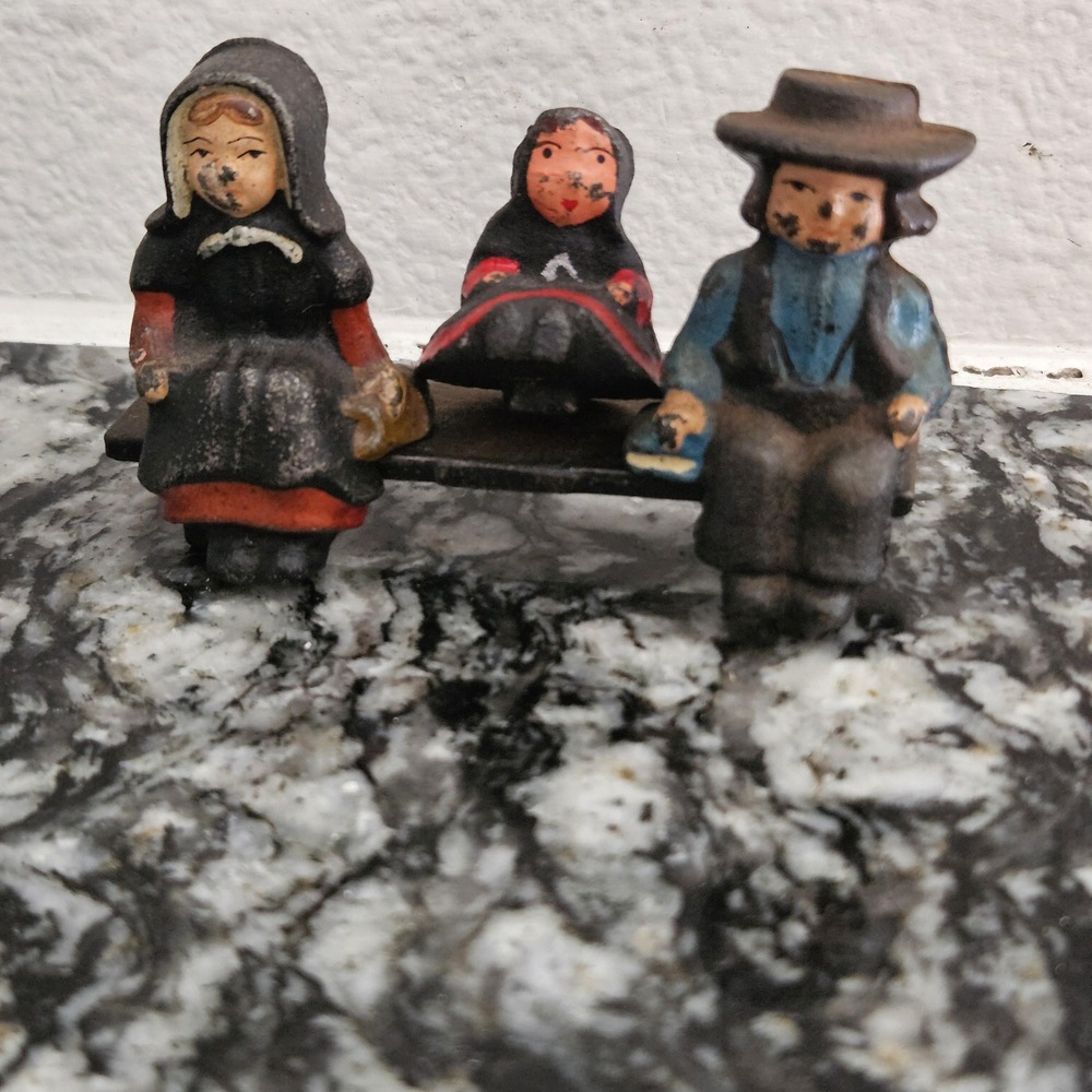 a‎ set of vintage cast iron Amish 3 figurines on a bench